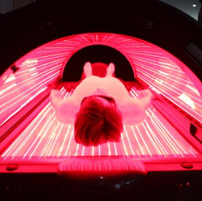 Person relaxing in red light therapy